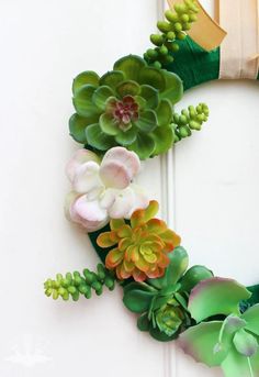 a wreath made out of fake succulents and leaves