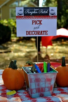 some pumpkins are sitting on a table with a sign that says pick and decorate