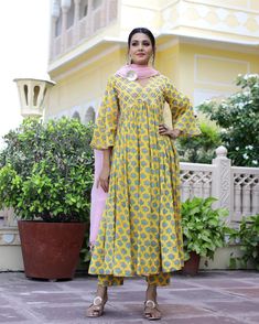 This is a 3-piece set. It comes with soft cotton hand block print anarkali kurta with gota detailing on the neck has 3/4th flared sleeves & ankle length.The set also comes with handblock print pants with semi elasticated waistband and kota doria dupatta with gota patti detailing. Color-Yellow Kurta Fabric-Voil Cotton Bottom Fabric-Voil Cotton Dupatta Fabric-Kota Doria Work-Block Print & Gota Patta Detailing Neck-V Neck Sleeves-3/4th Flared Sleeves Washing Care-Dry Clean Only Block Print Anarkali, Printed Anarkali Suits, Anarkali Kurta Set, Cotton Anarkali Kurta, Yellow Kurta, Mens Wear Wedding, Printed Anarkali, Cotton Anarkali, Reception Look