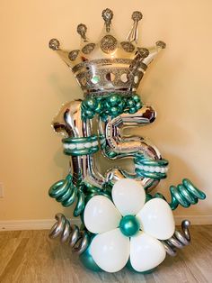 the balloon sculpture is decorated with silver, green and white balloons