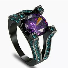 a purple ring with blue and green stones on it's sides, set in black stainless steel