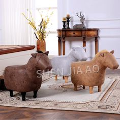 three wooden animals sitting on top of a rug in front of a table with flowers