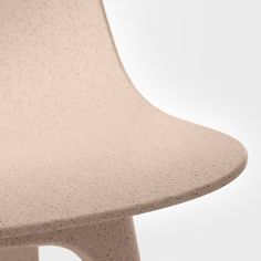 a close up of a chair with a white back and light pink seat cover on it