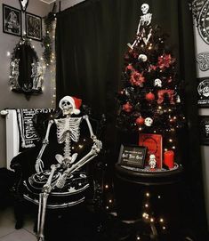 a skeleton sitting in a chair next to a christmas tree