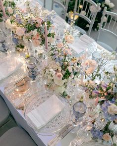 the table is set with flowers, candles and glassware for an elegant wedding reception