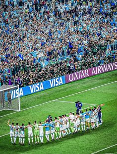 a group of men standing on top of a soccer field in front of a crowd