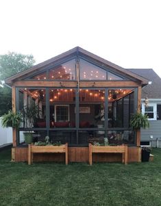 an image of a screened in porch with lights on the roof and plants growing inside