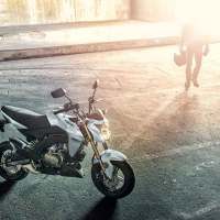 the motorcycle is parked on the side of the road in front of a person walking