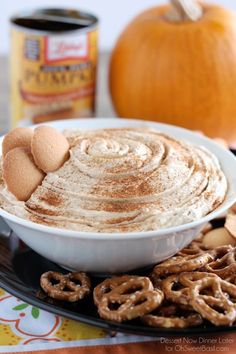 a plate with some pretzels on top of it next to an orange pumpkin