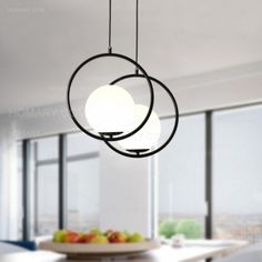 a modern chandelier hangs from the ceiling in an open room with large windows