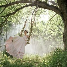 a woman in a white dress is swinging on a tree branch with the words posted by lois wedding ideas