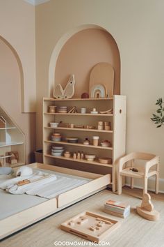 A cozy, minimalist children's room featuring a light wooden bookshelf filled with natural wooden toys, a simple bed with white bedding, and a modern wooden chair, all set against soft beige and peach walls. Small Play Area Ideas, Playroom Design Indoor Playground, Small Play Area, Waldorf Playroom, Colorful Playroom