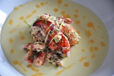 a white plate topped with food on top of a yellow and white table cloth covered in dots