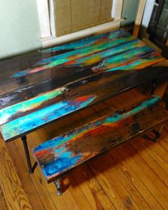 a table with two benches sitting on top of it in front of a door and window