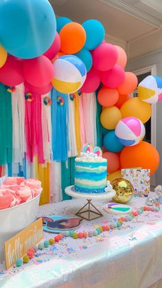 there is a cake and balloons on the table