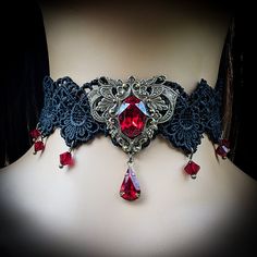 "This vintage gothic styled crystal choker necklace features captivating Siam Red Swarovski crystals with nice crisp facets and brass embellishments.  The detailed stampings have been in production since the 1940's and the vintage 16x11mm focal crystal is no longer in production, making this necklace a rare find.  The lace is double-layered and hand sewn together for extra durability. Both elegant and stylish, this piece would be perfect for any formal occasion. Swarovski Crystals are made in Austria and are the highest quality lead free glass-cut crystals on the market, with extra facets and gold foiling for outstanding brilliance and sparkle. The choker lace is 12.5\" long and includes a 3\"extension chain, totaling 15.5\" of length.  A pretty gold colored star hangs down from the chain Gothic Costume Jewelry Choker, Red Gothic Jewelry For Party, Gothic Costume Choker Necklace, Victorian Silver Costume Jewelry, Formal Gothic Metal Choker, Victorian Rhinestone Jewelry For Gifts, Victorian Rhinestone Jewelry Gift, Gothic Red Ruby Jewelry, Steampunk Choker Jewelry Gift