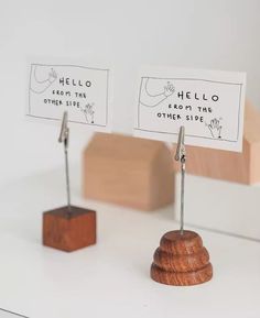 there are two small wooden pieces on top of each other with name tags attached to them