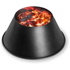 a fire pit sitting on top of a black stand with flames coming out of it