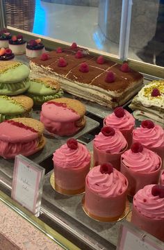 a display case filled with lots of different types of cakes and desserts on top of it