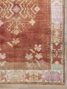 an old rug with many different colors and patterns on the carpet, including pinks