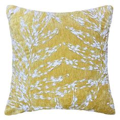 a yellow pillow with white leaves on it