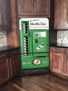 an old fashioned mountain dew vending machine sits in the middle of a kitchen with wooden cabinets