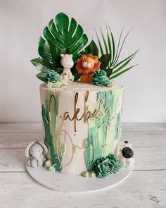 a cake decorated with jungle animals and leaves