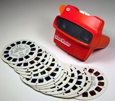 a red toy camera sitting on top of a table next to some white coasters