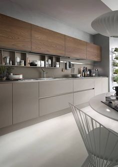 a modern kitchen with white counter tops and wooden cabinets, along with a large window