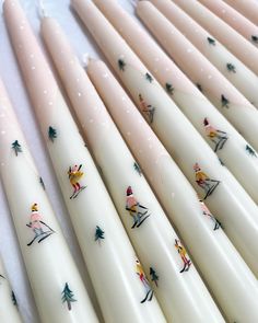 several white candles with designs on them sitting next to each other