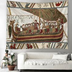 a tapestry hanging on the wall above a couch in a living room with a white sofa