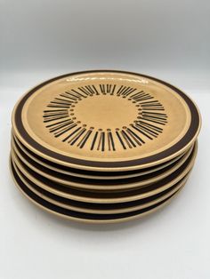 six black and gold plates stacked on top of each other