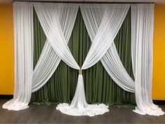 a room with green curtains and white drapes