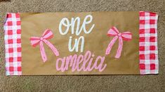 a brown paper bag with pink bows and the words one in america painted on it