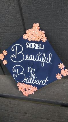 a blue graduation cap that says screen beautiful by brilliant on the front with flowers around it