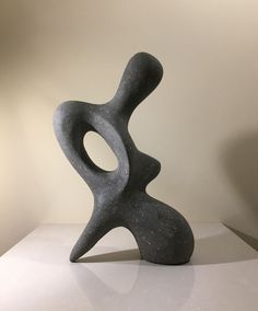 a gray sculpture sitting on top of a white table