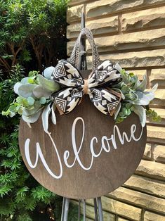 a welcome sign with a bow hanging from it