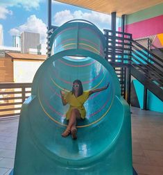 a woman sitting on top of a blue slide