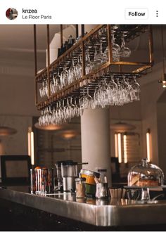 a bar with many wine glasses hanging from it's ceiling and on the counter