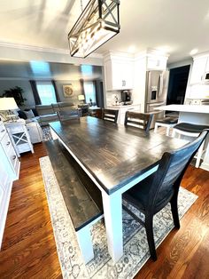 a large kitchen with an island table and chairs next to the counter top in front of it