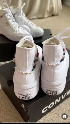 two pairs of white sneakers with pearls on them