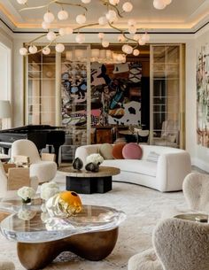 a living room filled with white furniture and lots of chandelier hanging from the ceiling