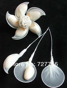 three pieces of white plastic flowers on a black background