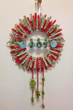 a christmas wreath with the word joy hanging from it's side on a wall