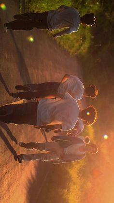 three people standing on the side of a road with their hands in each other's pockets