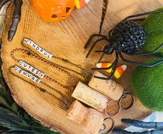 halloween decorations including pumpkins, scissors and other items are arranged on a tree stump