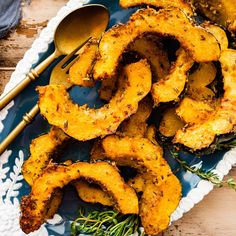 some fried food is on a blue plate with spoons and fork next to it