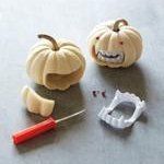 two carved pumpkins are sitting next to a pair of scissors