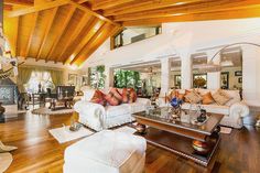 a living room filled with lots of furniture and wooden flooring next to a fire place