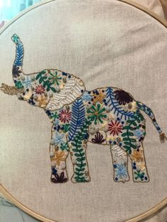 an elephant with flowers and leaves on it's back is shown in the hoop